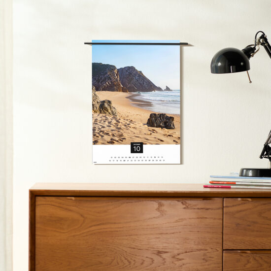 der fineline wandkalender an einer wand, daneben eine tischleuchte auf einem sideboard
