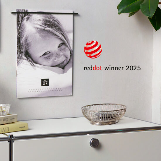 fineline wandkalender an einer wand, daneben ein der red dot winner 2025 award