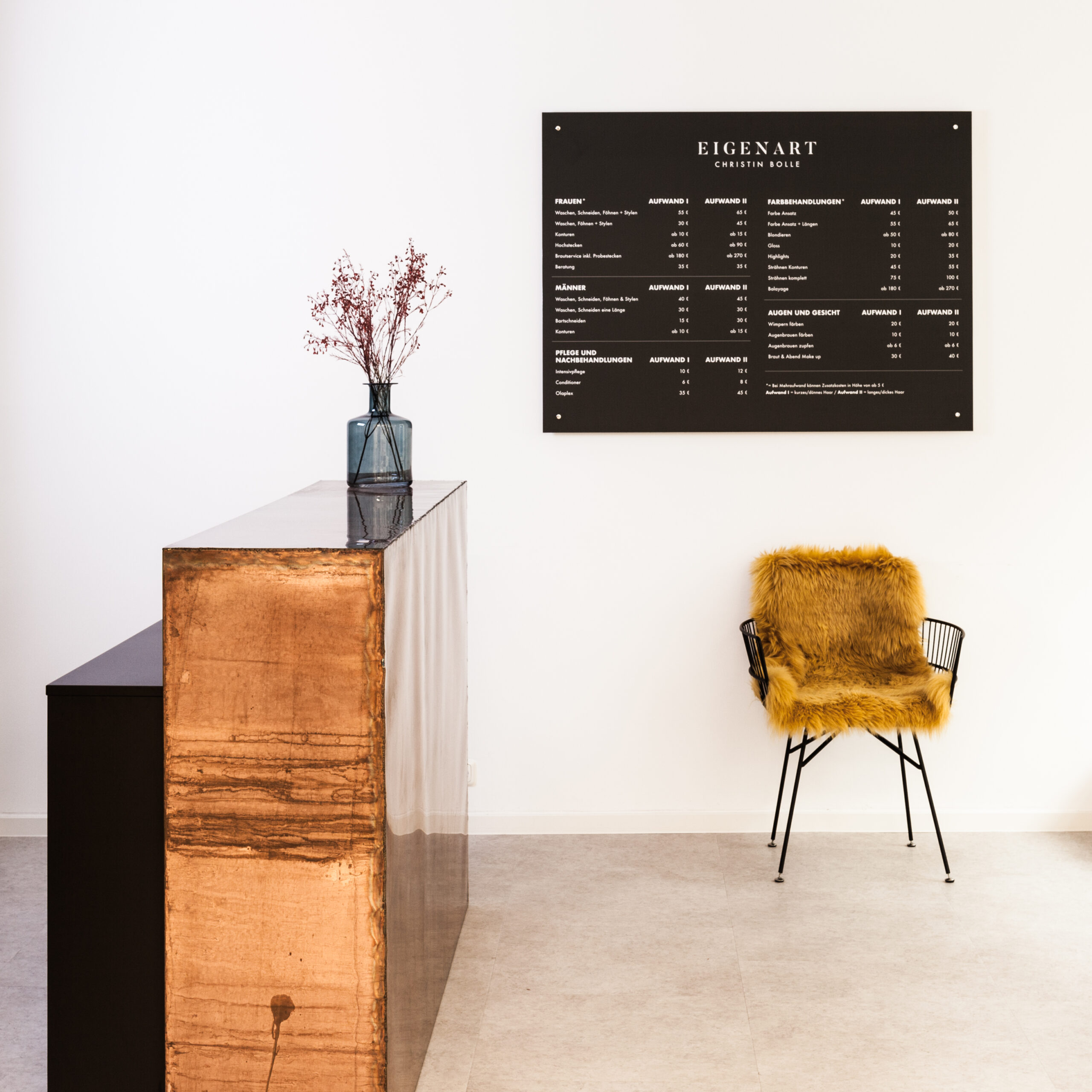 moderner empfangsbereich mit metallenem tresen und angebotstafel in schwarz-weiß