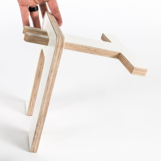 eine hand hält einen skateboardständer aus multiplex plattenmaterial und zeigt, dass es gesteckt ist