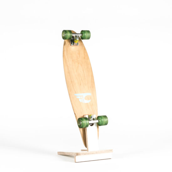 ein skateboard mit grünen rollen, aufgestellt in einem ständer aus multiplex plattenmaterial