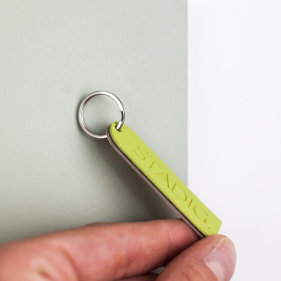 eine hand hält ein schlüsselband, dass an einem grünen magentischen band hängt