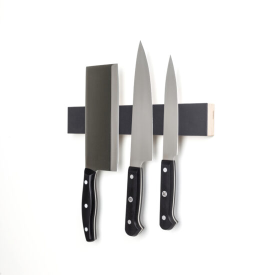an einem dunkelgrauen schmalen und magentischen messerbrett hängen drei küchenmesser