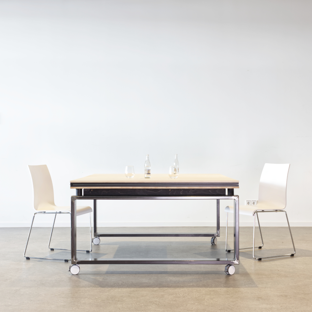 ein raum mit dem tischtennis-konferenztisch von studio ole marten und zwei weißen stühlen