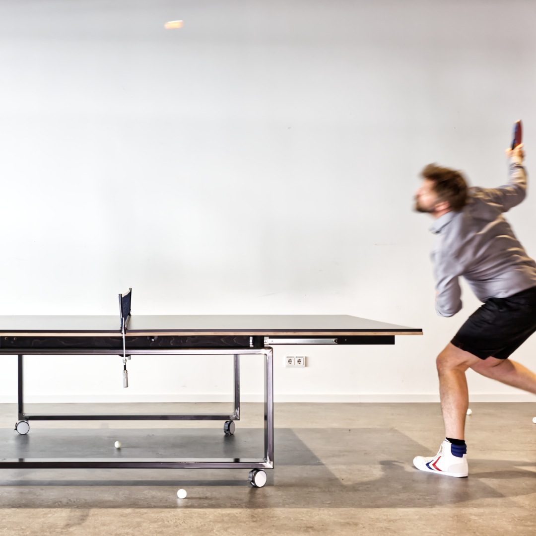 ein mann spielt tischtennis am tischtennis-konferenztisch von studio ole marten